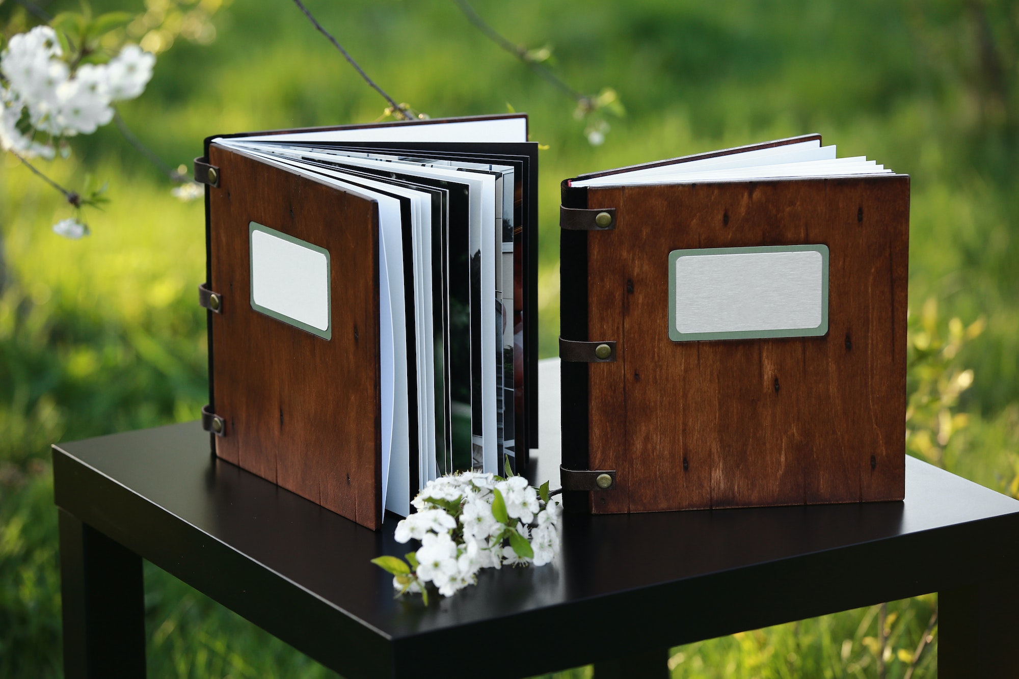 two wooden photo books on the table in the nature. place for the inscription